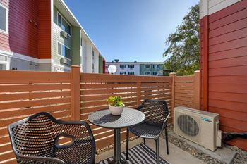 a patio with two chairs and a table on a balcony  at Track 281 Apartments, California